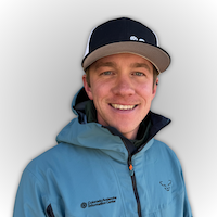 Chris Dickson, Southern Mountains Backcountry Forecaster for CAIC, smiling and wearing a blue jacket against a light grey background